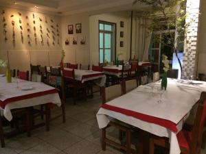 a restaurant with tables with red and white tablecloths at Hotel Eldorado Inn in Feira de Santana