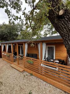 a log cabin with a porch and a tree at Moon apartments in Pakoštane