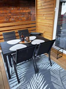 a black table with chairs and a bottle of beer at Moon apartments in Pakoštane +21 photos