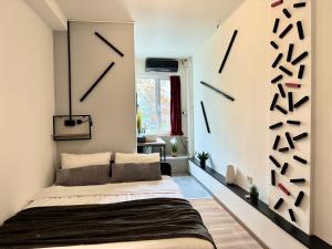 a bedroom with a bed with clocks on the wall at E - Central Room Two in Skopje