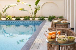 a tray of food next to a swimming pool at Niwasa - A Luxury Boutique Stay, Udaipur in Udaipur