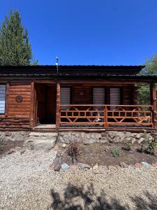 a log cabin with a fence in front of it at cabañas de montaña Triskel in Aluminé +8 photos