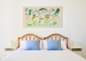 a bedroom with a white bed with blue pillows at La Dimora di Ulisse in Santa Cesarea Terme