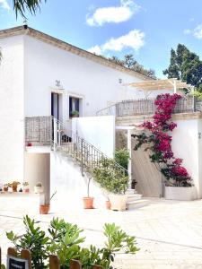 a white house with flowers in front of it at La Dimora di Ulisse in Santa Cesarea Terme