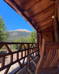a rocking chair on the porch of a cabin with a view at cabañas de montaña Triskel in Aluminé