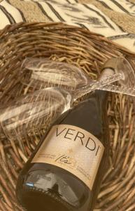 a bottle of wine in a wicker basket at Stenbækgård - Farm Glamping in Højslev