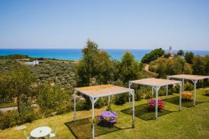 two gazebos with tables and chairs in a field at Agriturismo biologico 'A Lanterna in Marina di Monasterace