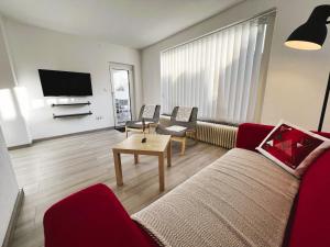 a living room with a red couch and a tv at Moida-Ferienwohnung in Fügen