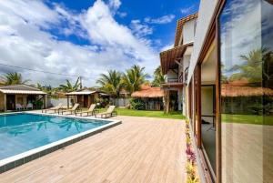 a villa with a swimming pool and a house at Villa Manoá in São Miguel dos Milagres