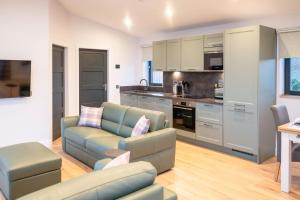 a living room with a couch and a kitchen at Bennachie Lodge in Huntly +21 photos