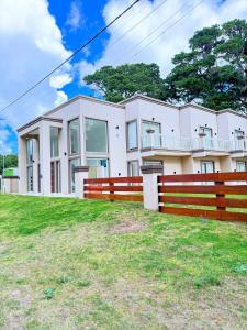 a large white house with a fence in front of it at La mansa del pinar in La Lucila del Mar