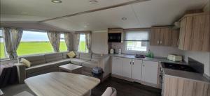 a kitchen and living room with a couch and a table at Sea view 1 in Heysham