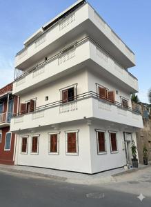a white building with balconies on a street at Hôtel La Maison Blanche in Saint-Louis