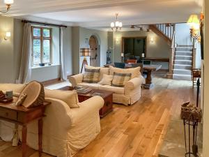 a living room with two couches and a staircase at Church Barn in Olney