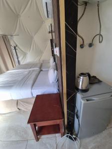 a small bedroom with a bed and a table at Sofia Bubble Luxury Camp in Disah +35 photos