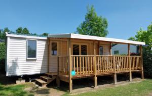 a tiny house with a porch and a deck at Oasis des Garrigues in Vogüé