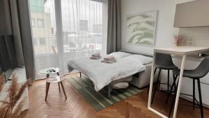 a small bedroom with a bed and a large window at VApartment Nova Vajnorska , private parking in Koliba