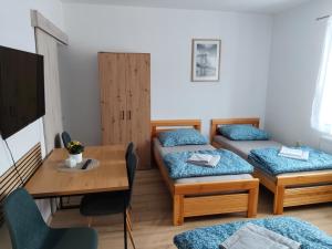 a room with two beds and a table and a dining room at Apartmán 38 in Opolany