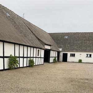 a row of white buildings with a roof at Sommerliv Bed and Breakfast in Tranekær +10 photos