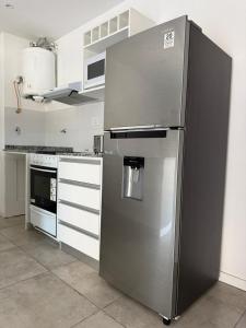 a large stainless steel refrigerator in a kitchen at Altostay in Villa Constitución