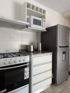 a kitchen with a stove and a refrigerator at Altostay in Villa Constitución