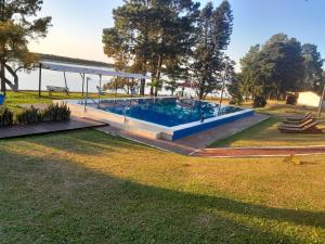 a swimming pool in a park with trees and grass at Paraíso Yapeyu in Yapeyú