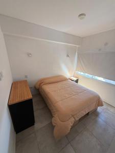 a bedroom with a bed and a wooden table at Altostay in Villa Constitución
