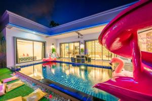 a swimming pool with a slide in a house at Flamingo Na Jomtien in Na Jomtien