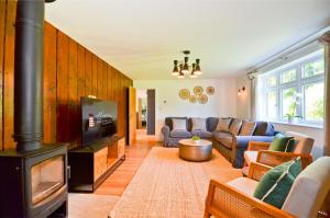 a living room with a couch and a fireplace at Adgestone Villa - A Luxurious Countryside Escape with Heated Pool, Near Sandown Beach, Dog Friendly in Rural Sandown - Perfect Getaway for Family & Friends in Alverstone