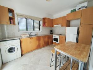 a kitchen with a washer and a table in it at Sunset View in Polis Chrysochous