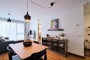 a living room with a table and a couch at Llanes Celorio Piscina y Playa – El Castro Borizu in Celorio