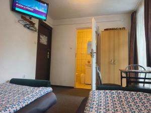 a hotel room with two beds and a tv on the wall at Męcikówka in Szczyrk