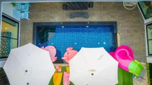 two white umbrellas in front of a swimming pool at Flamingo Na Jomtien in Na Jomtien