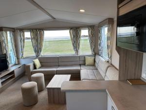 a living room with a couch and a tv at Sea view 1 in Heysham