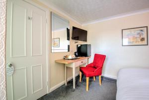 a room with a desk and a red chair at Potters Mooring Guest House in Teignmouth +5 photos