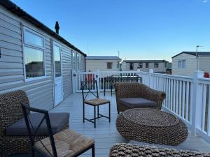 a deck with chairs and tables on a house at Sea view 1 in Heysham
