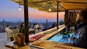 a man sitting at a bar on top of a restaurant at River Crossing Lodge in Windhoek