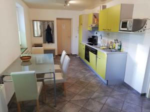 a kitchen with a table and a kitchen with yellow cabinets at Apartment Sayda 4 in Sayda