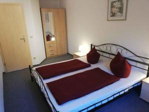 a bedroom with a bed with red pillows on it at Apartment Sayda 4 in Sayda