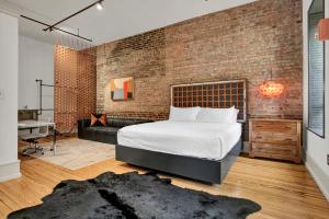 a bedroom with a bed and a brick wall at Luxe 220 Suite 2 in Wilmington