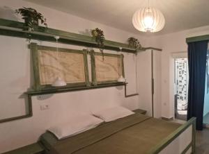 a bedroom with a bed with two plants on the wall at Guest House Green Corner Supetarska Draga in Supetarska Draga