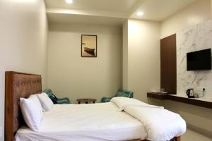 a hotel room with a bed and a tv at Shagun Hotel & Banquet in Lucknow +82 photos