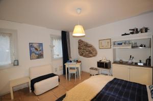 a bedroom with a bed and a table and a kitchen at Casa Novecento "Rooms & apartments" in Feltre