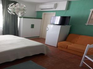 a room with a bed and a chair and a refrigerator at Guest House Green Corner Supetarska Draga in Supetarska Draga