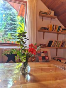 a vase with flowers on a table in front of a window at Penzion Bor in Náchod