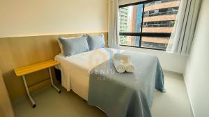 a bedroom with a bed with a table and a window at Unigreen Manaíra Genius Flats in João Pessoa +20 photos