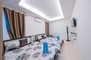 a living room with two beds and a tv at Flamingo Na Jomtien in Na Jomtien +30 photos