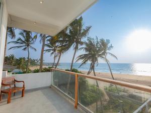 a balcony with a view of the beach at Kavin Beach Hotel Hikkaduwa in Hikkaduwa