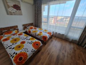 a bedroom with two beds and a large window at Large Two Floor Apartment in Byala