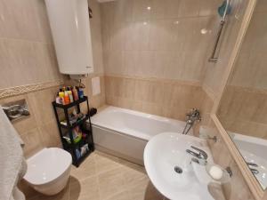 a bathroom with a sink and a tub and a toilet at Large Two Floor Apartment in Byala